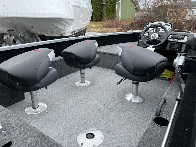Slide: The Image of 2023 Alumacraft Competitor 165 SC boat interior with three seats and steering console. - 4