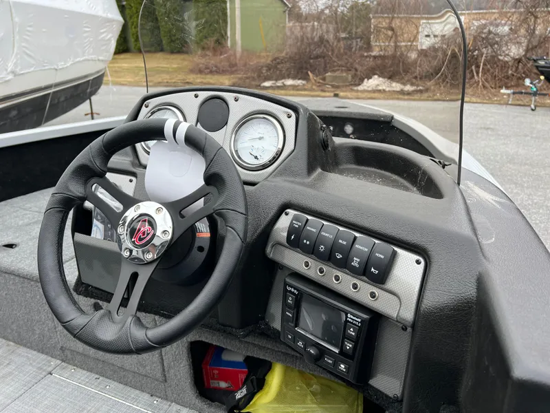 Slide: The Image of 2023 Alumacraft Competitor 165 SC boat dashboard with steering wheel and control panel. - 5