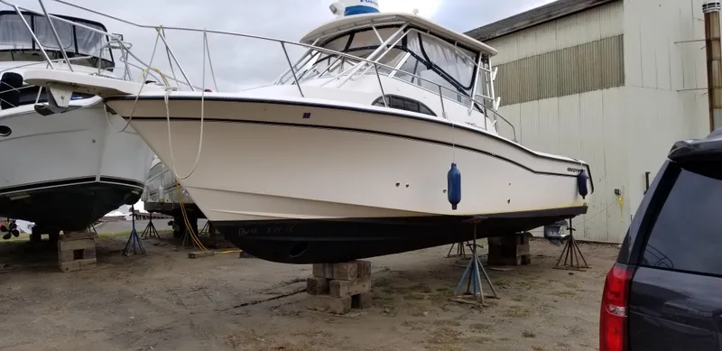 Slide: The Image of 2005 Grady-White Marlin 300 boat on stands in a boatyard. - 0