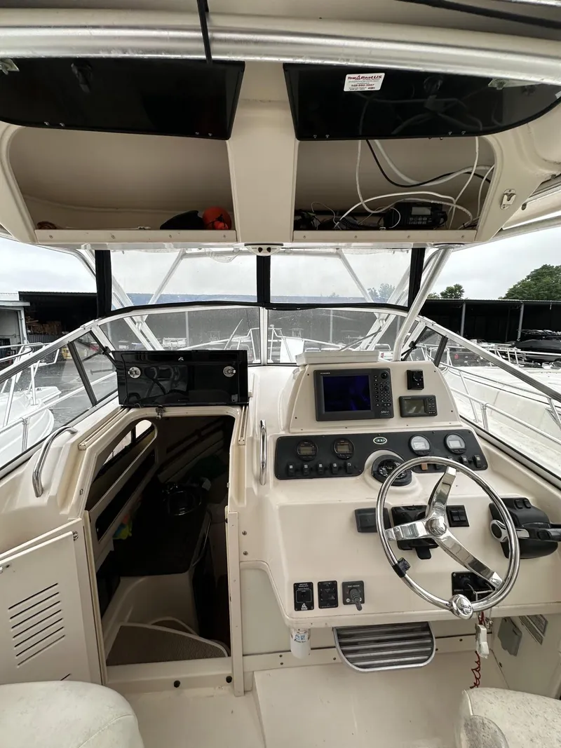 Slide: The Image of 2005 Grady-White Marlin 300 boat cockpit with steering wheel and navigation controls. - 12