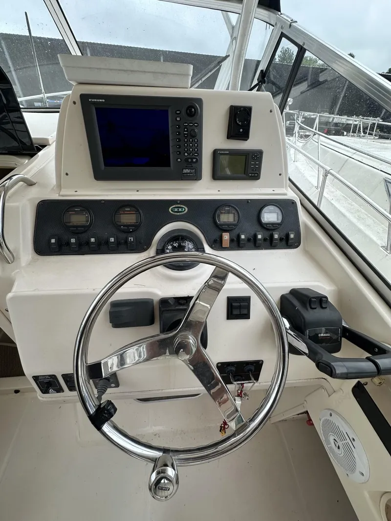 Slide: The Image of 2005 Grady-White Marlin 300 boat dashboard with steering wheel and navigation instruments. - 13