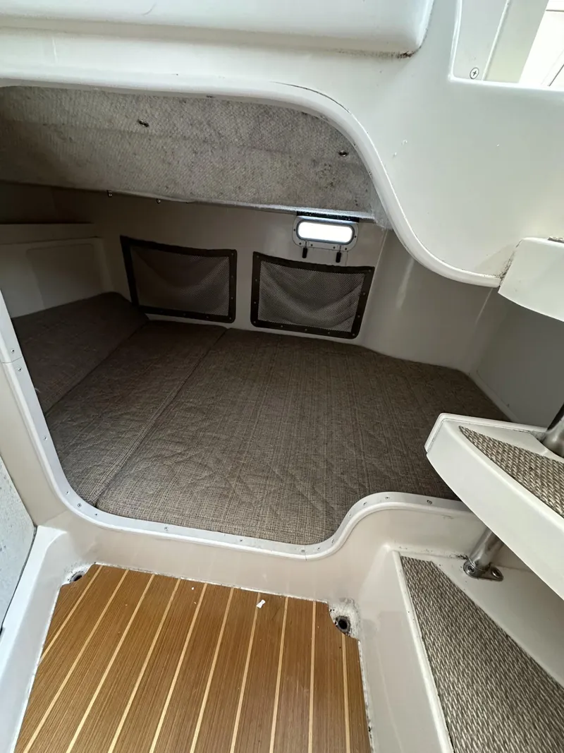 Slide: The Image of 2005 Grady-White Marlin 300 cabin interior with carpeted flooring and storage compartments. - 24
