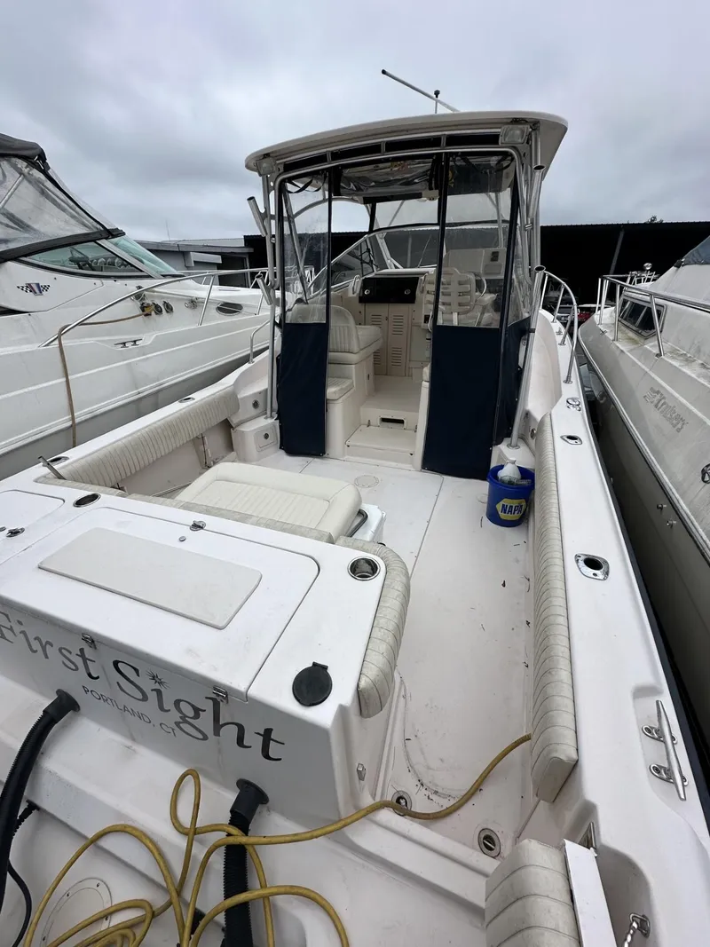 Slide: The Image of 2005 Grady-White Marlin 300 boat docked, featuring spacious deck and seating area. - 4