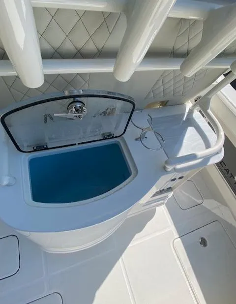 Slide: The Image of 2024 World Cat 280 CC-X boat interior with livewell and rod holders. - 8