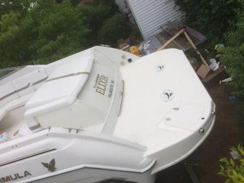 Slide: The Image of 2000 Formula 33SS boat, rear view, white exterior, docked near greenery and a house. - 4