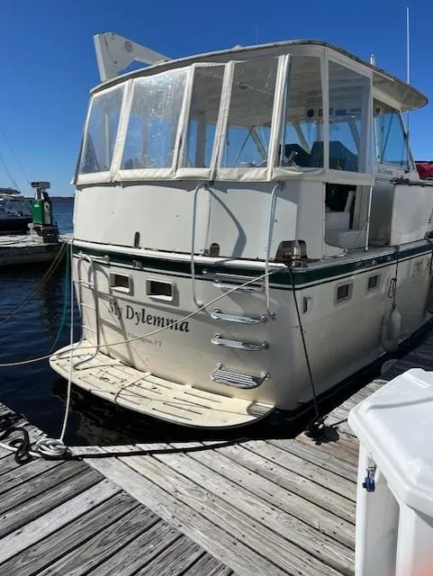 Slide: The Image of 1971 Hatteras 43 Double Cabin yacht docked, featuring a spacious rear deck and enclosed cabin. - 1