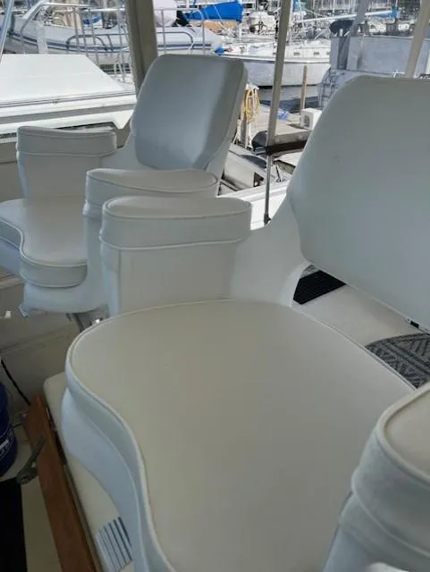 Slide: The Image of 1971 Hatteras 43 Double Cabin with white seating in a marina setting. - 12