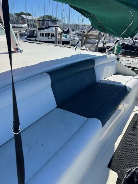 Slide: The Image of 1971 Hatteras 43 Double Cabin boat with cushioned seating and marina backdrop. - 16