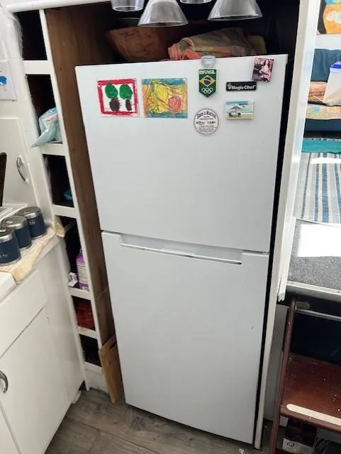 Slide: The Image of White refrigerator with colorful magnets in a 1971 Hatteras 43 Double Cabin kitchen. - 24