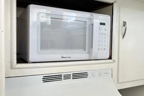 Slide: The Image of White microwave in a kitchen cabinet on a 1971 Hatteras 43 Double Cabin boat. - 26