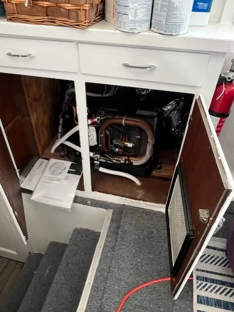 Slide: The Image of 1971 Hatteras 43 Double Cabin interior showing open cabinet with mechanical components. - 27