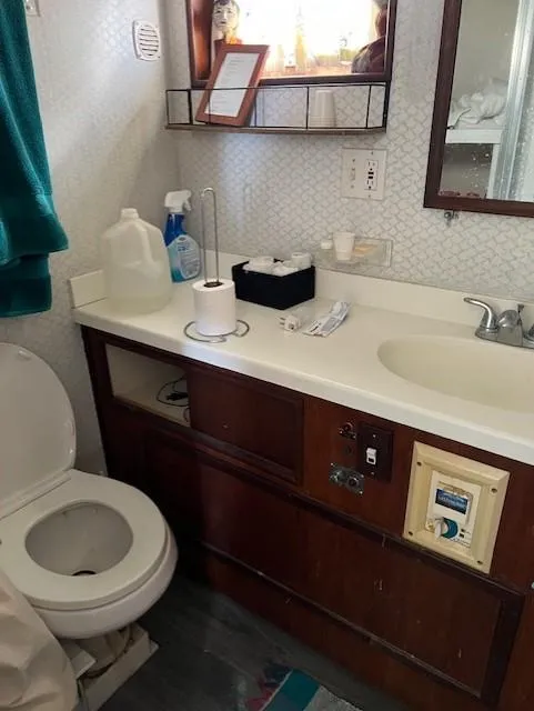 Slide: The Image of 1971 Hatteras 43 Double Cabin bathroom with sink, toilet, and toiletries. - 34