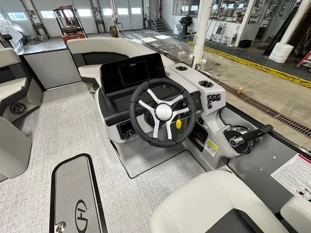Slide: The Image of 2024 Harris Cruiser 210 CWDH boat interior with steering wheel and control panel. - 19