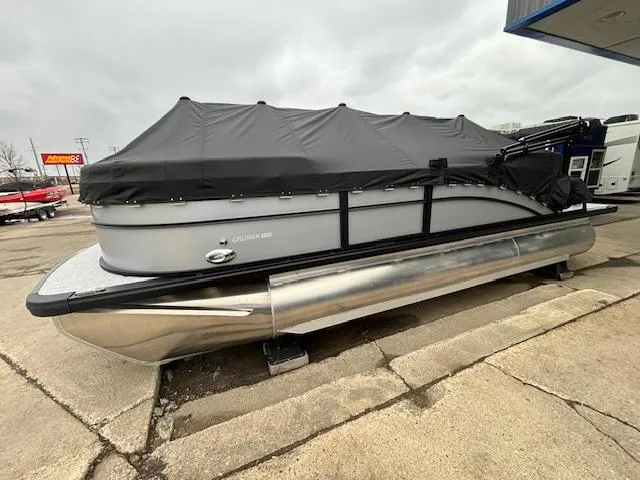Slide: The Image of 2024 Harris Cruiser 210 CWDH pontoon boat with black cover on a trailer. - 3