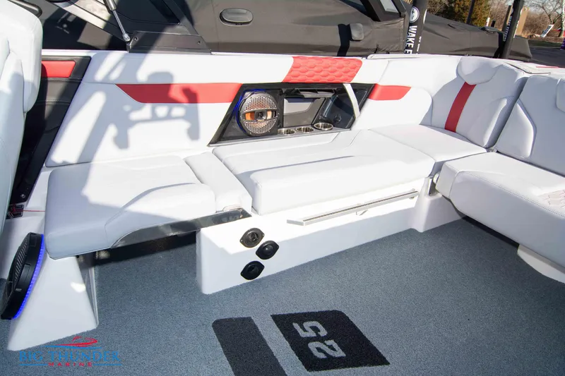 Slide: The Image of 2024 MasterCraft XT25 boat interior with white and red seating and advanced audio system. - 17