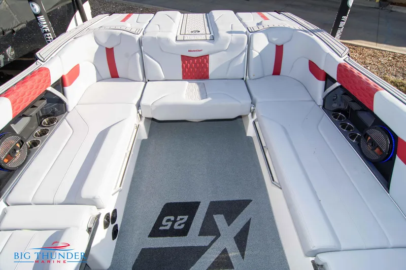 Slide: The Image of 2024 MasterCraft XT25 boat interior with white and red seating, Big Thunder Marine logo. - 21