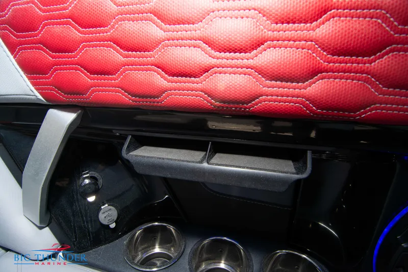 Slide: The Image of 2024 MasterCraft XT25 interior detail with red upholstery and cup holders. - 25