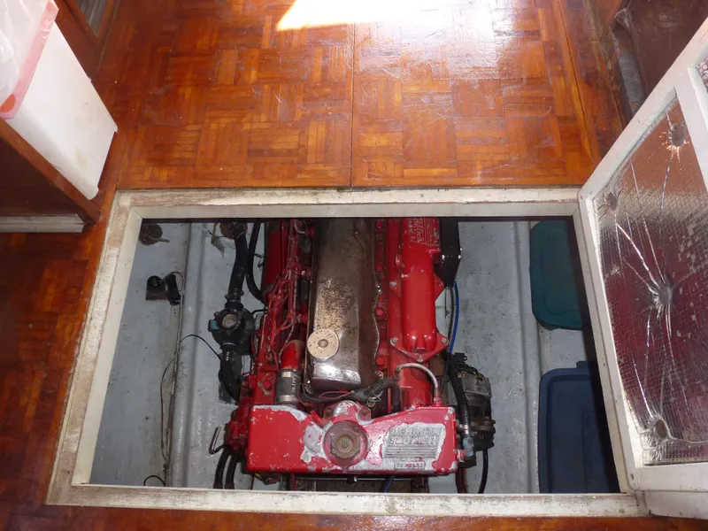 Slide: The Image of Engine compartment of a 1983 Island Gypsy Trawler with visible red engine. - 16