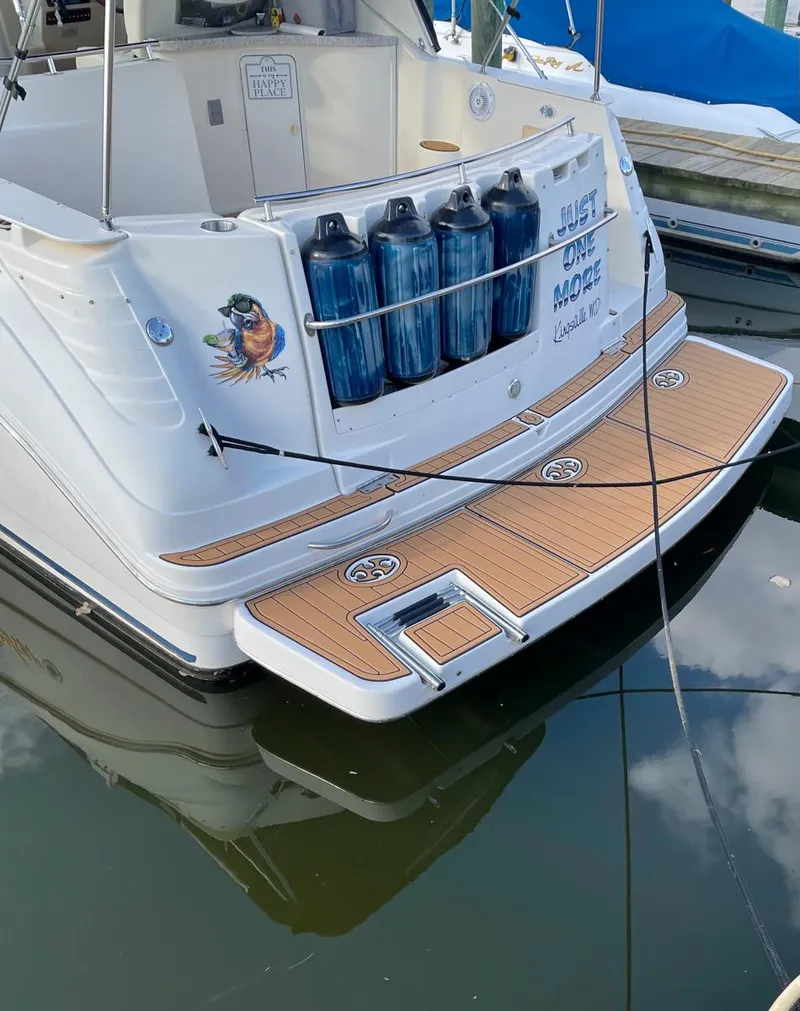 Slide: The Image of 2001 Rinker 310 Fiesta Vee boat docked with wooden swim platform. - 1