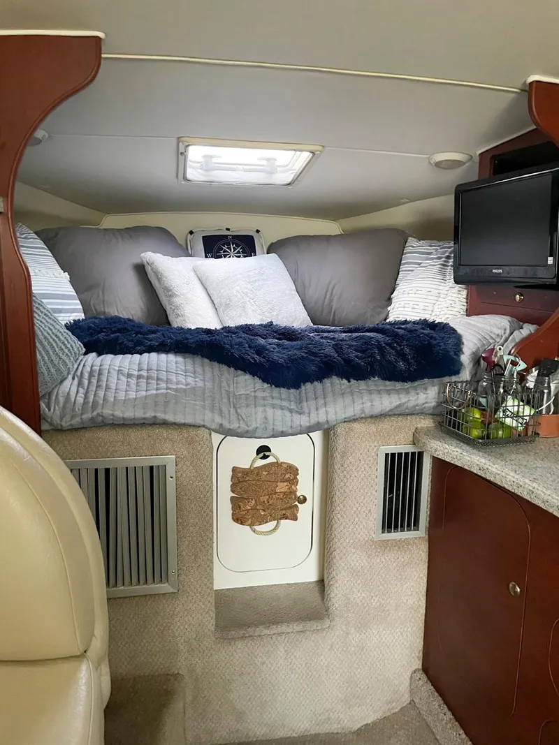 Slide: The Image of Interior cabin of 2001 Rinker 310 Fiesta Vee with cozy bedding and TV. - 6