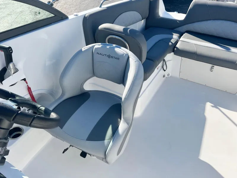 Slide: The Image of 2024 NauticStar 223DC boat interior with gray and white seating. - 10