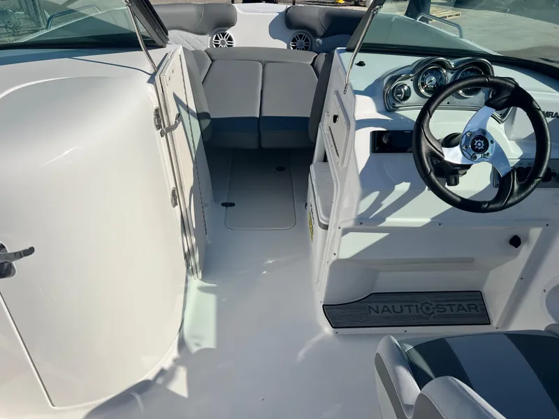 Slide: The Image of 2024 NauticStar 223DC boat interior with steering wheel and seating area. - 4