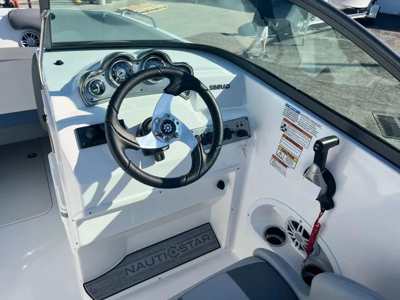 Slide: The Image of 2024 NauticStar 223DC boat dashboard with steering wheel and control panel. - 5