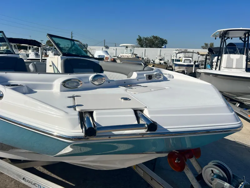 Slide: The Image of 2024 NauticStar 223DC boat on trailer, front view, in a marina. - 6