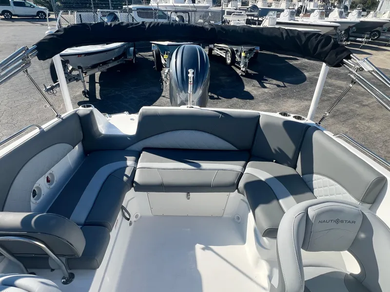 Slide: The Image of 2024 NauticStar 223DC boat interior with seating and outboard motor. - 8