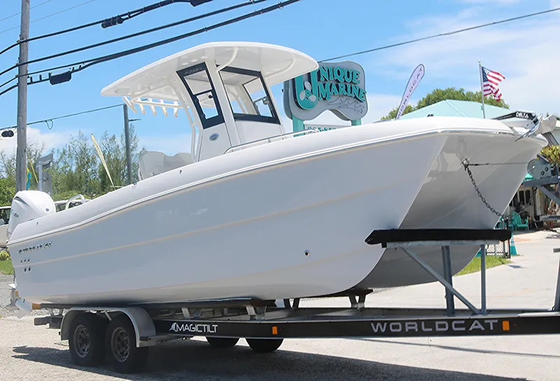 Slide: The Image of 2025 World Cat 235TE boat on a trailer at Unique Marine dealership. - 2