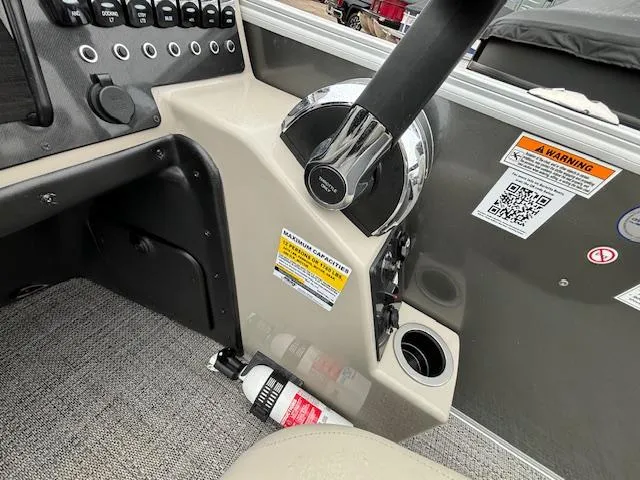 Slide: The Image of 2024 Barletta ARIA 22UC boat helm with steering wheel, controls, and safety labels. - 22