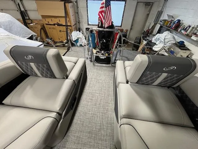 Slide: The Image of 2024 Barletta Lusso 23M luxury pontoon boat interior with plush seating and American flag. - 11