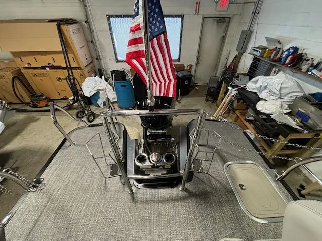 Slide: The Image of 2024 Barletta Lusso 23M pontoon boat interior with American flag in a garage. - 13