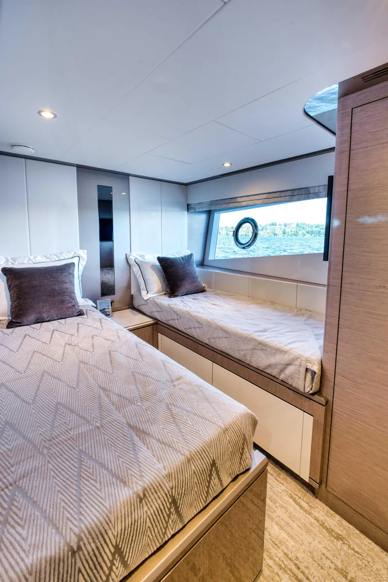 Slide: The Image of Luxurious twin bedroom in 2024 Ocean Alexander 32L yacht with modern decor and large window. - 22