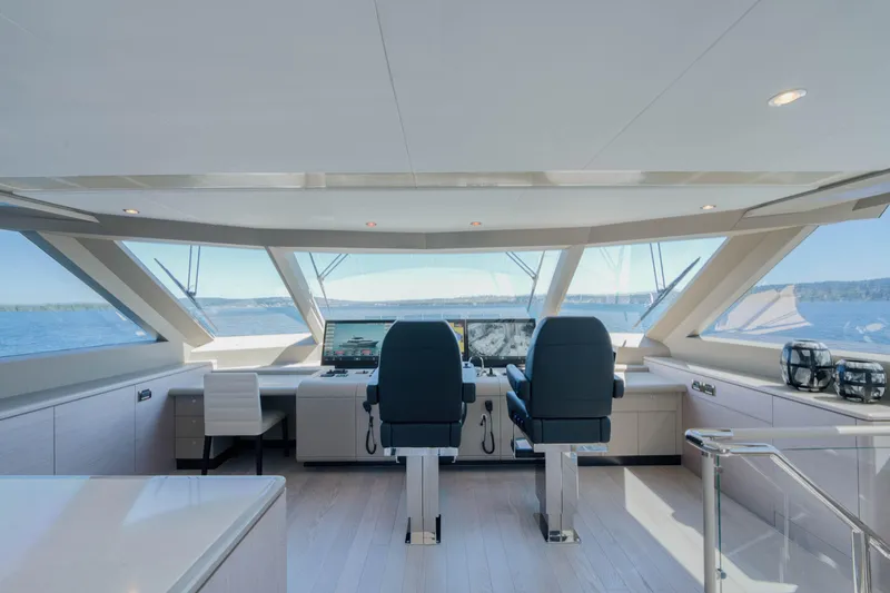 Slide: The Image of 2024 Ocean Alexander 32L yacht helm station with panoramic windows and modern seating. - 24