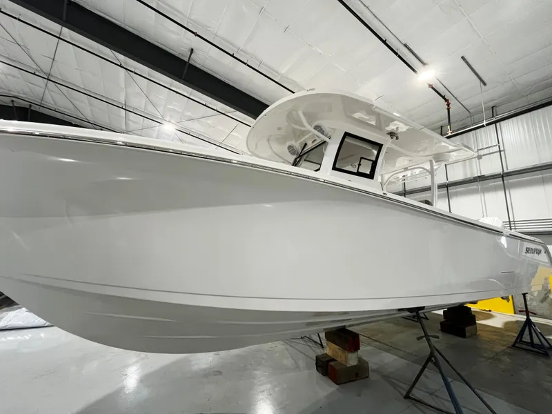 Slide: The Image of 2024 Sea Pro 322 DLX boat in a showroom. - 11