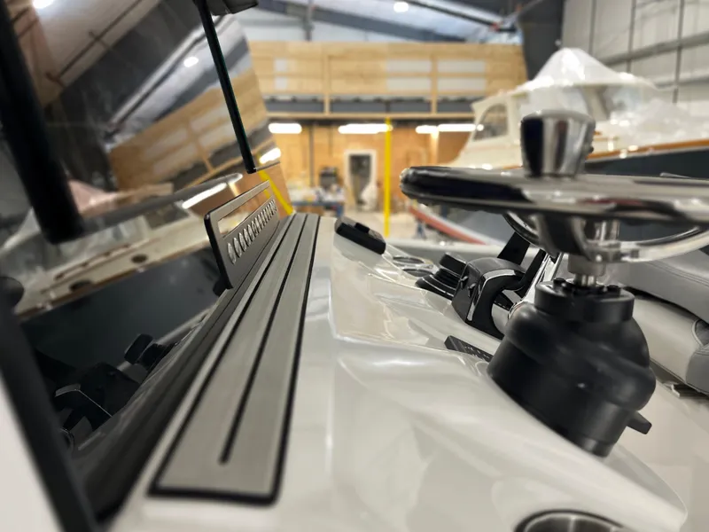 Slide: The Image of 2024 Sea Pro 322 DLX boat dashboard and steering wheel in a showroom. - 21