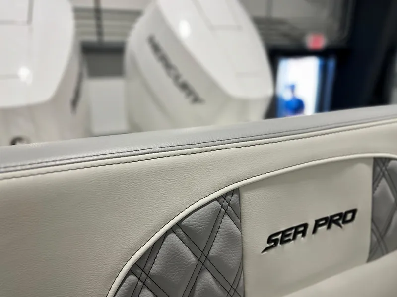 Slide: The Image of Close-up of 2024 Sea Pro 322 DLX boat seat with Mercury engines in background. - 7