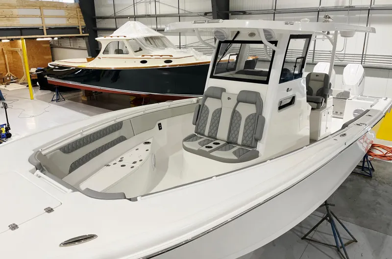 Slide: The Image of 2024 Sea Pro 322 DLX boat in a showroom, featuring spacious seating and modern design. - 8