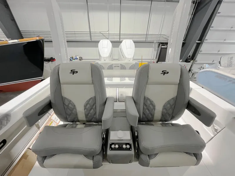 Slide: The Image of 2024 Sea Pro 322 DLX boat with dual captain's chairs in a modern interior. - 2