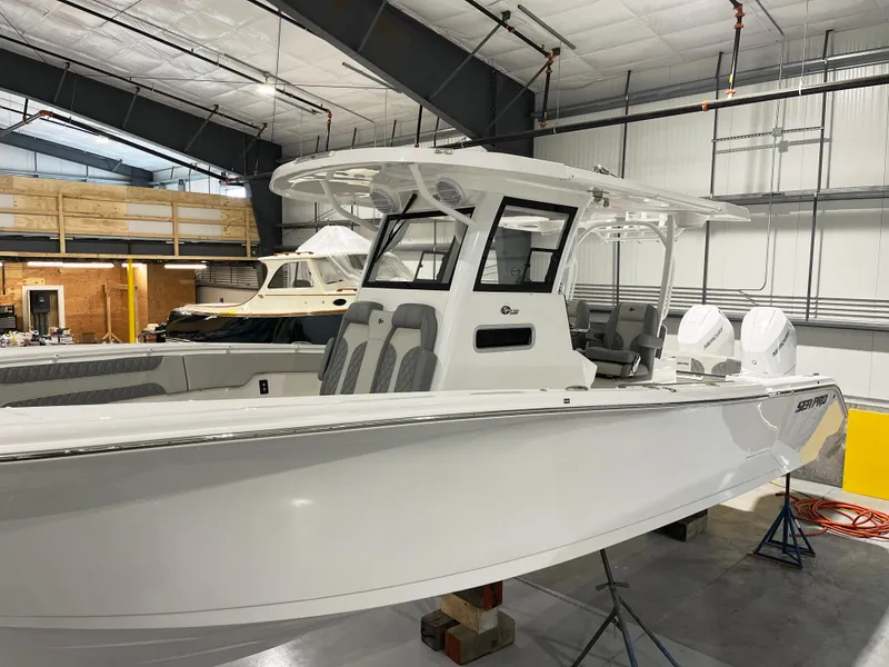 Slide: The Image of 2024 Sea Pro 322 DLX boat in a showroom, featuring a sleek white design. - 6
