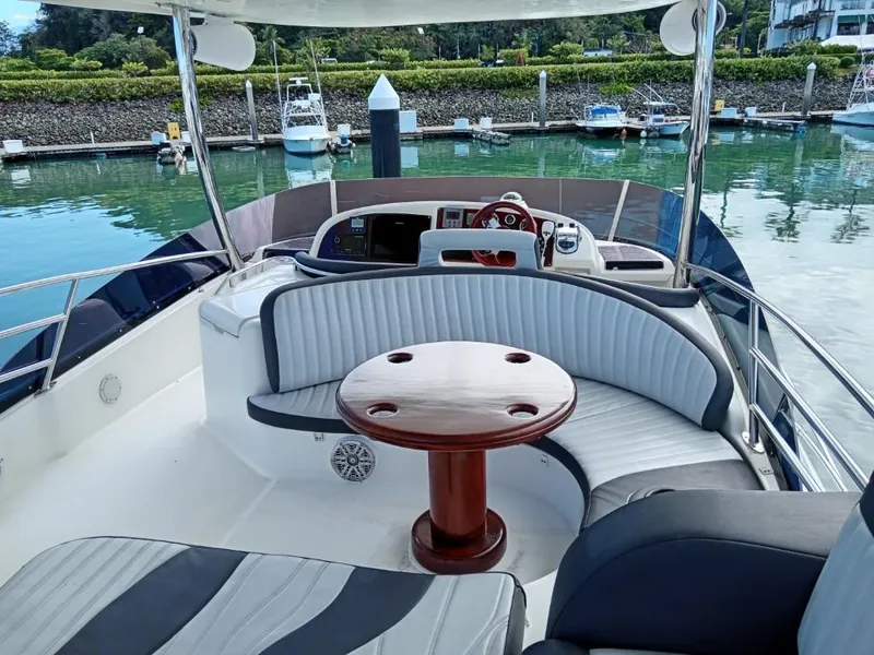 Slide: The Image of Prestige 46 yacht 2006 model, spacious deck with seating and table, docked at marina. - 14