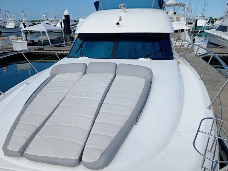 Slide: The Image of 2006 Prestige 46 yacht with sunbathing cushions on the deck, docked at a marina. - 16