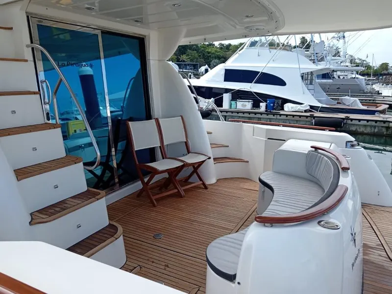 Slide: The Image of Prestige 46 yacht 2006 model, spacious deck with seating and wooden flooring, docked at marina. - 18