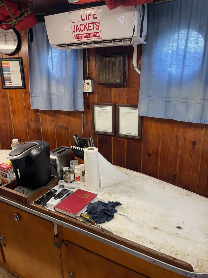 Slide: The Image of 1961 Commercial Model Bow Tug interior with wooden paneling and life jackets sign. - 20