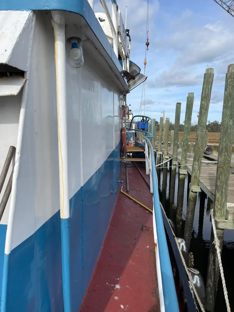 Slide: The Image of 1961 Commercial Model Bow Tug docked at a marina, side view. - 5