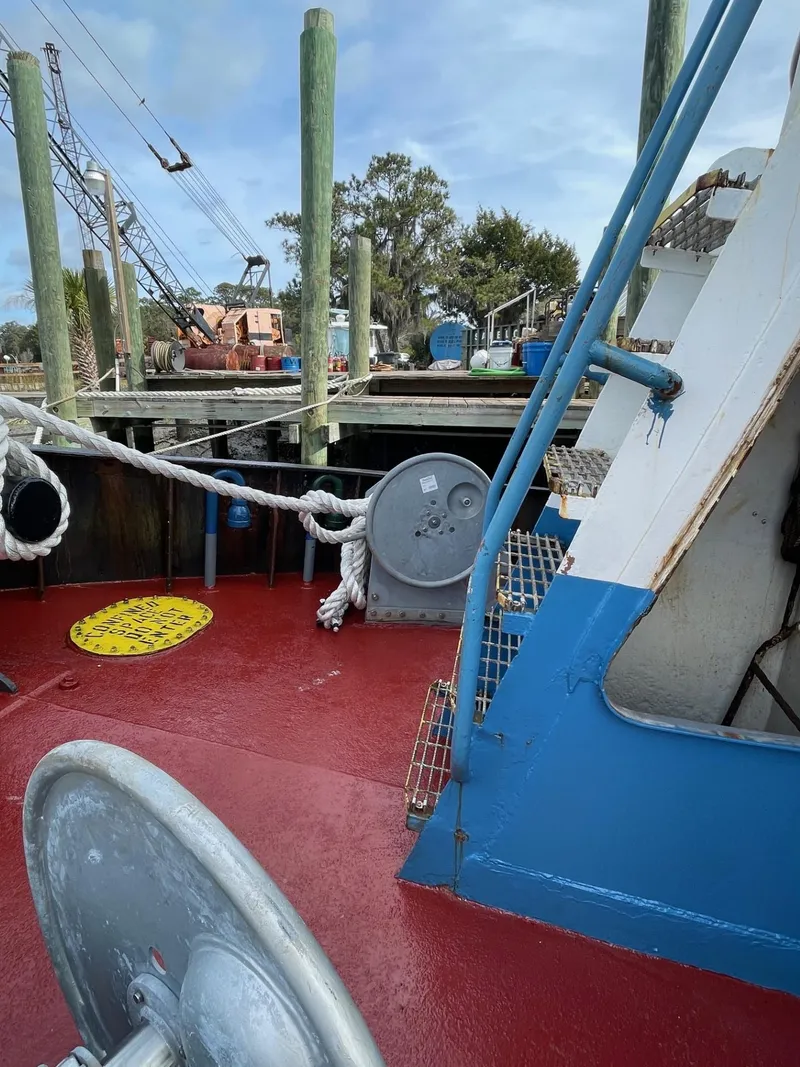 Slide: The Image of 1961 Commercial Model Bow Tug docked at a marina with ropes and equipment. - 7