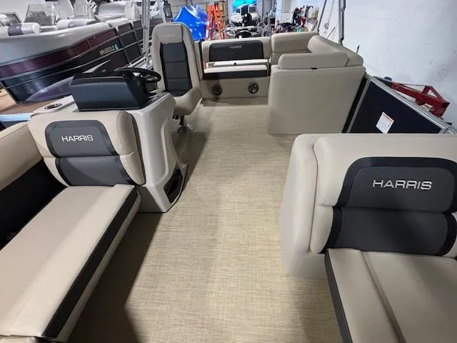 Slide: The Image of 2024 Harris Cruiser 210 pontoon boat interior with beige seating and steering console. - 7