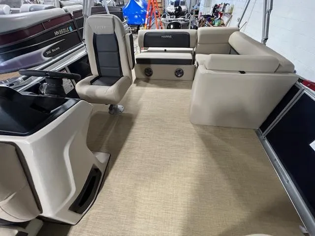 Slide: The Image of 2024 Harris Cruiser 210 boat interior with beige seating and steering console. - 8