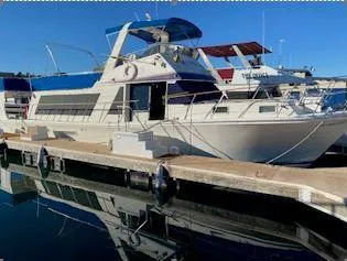 The Image of 1981 Blue Water Coastal Cruiser docked at marina, reflecting on calm water. - 0